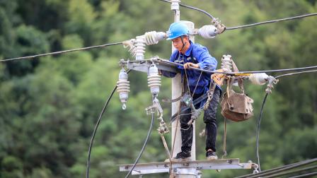 يصلحون شبكة كهرباء قرية سيان في رونغان الصينية، 2 يوليو 2024 (Getty)