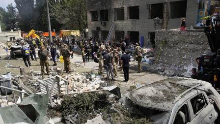 عمال إنقاذ وجنود أمام مستشفى كييف بعد تعرضه للقصف، 8 يوليو 2024 (Getty)