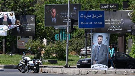 لافتات مرشحي انتخابات مجلس الشعب السوري 14 يوليو 2024 (فرانس برس)