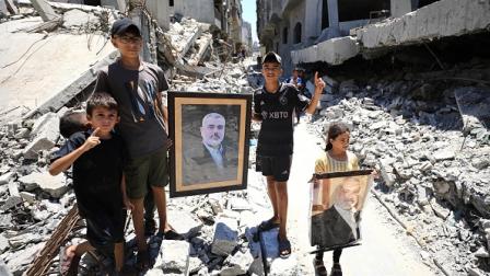أطفال بمدينة غزة يرفعون صور إسماعيل هنية، 31 يوليو 2024 (الأناضول)